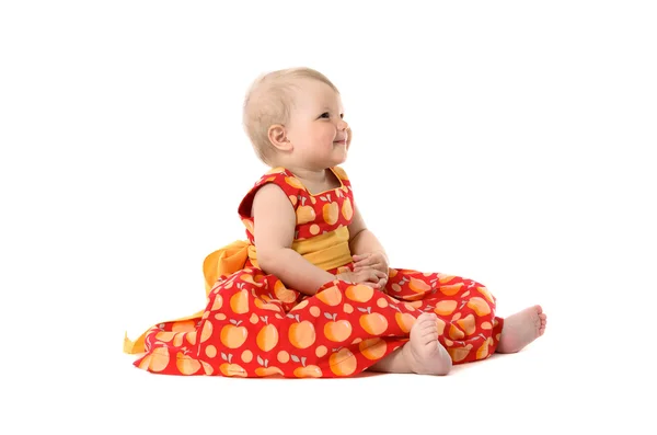 Katta oturan Kırmızı elbiseli kız sevimli küçük bebek — Stok fotoğraf