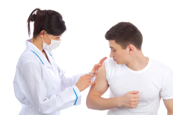 Arts vrouw in masker geven griepvaccinatie — Stockfoto