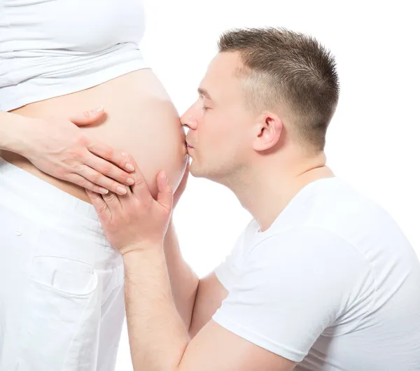 Мужчина целует живот своей беременной жены — стоковое фото
