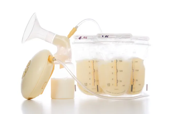 Breast pump and bags of frozen breastmilk — Stock Photo, Image
