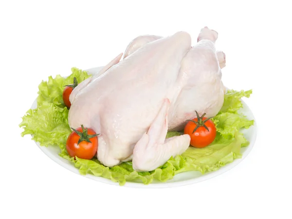 Ωμός αργού κοτόπουλο σε μια πιατέλα την οποία γαρνίρετε με λαχανικά — Φωτογραφία Αρχείου