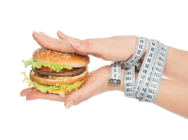 Burger cheeseburger in hands with measure tape — Stock Photo, Image