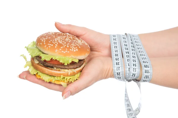 Burger cheeseburger in hands with measure tape — Stock Photo, Image