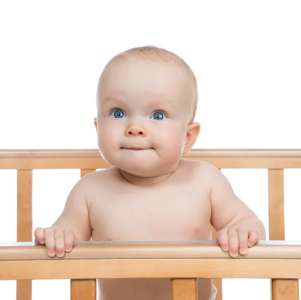 Infant child baby boy in wooden bed looking up — Stock Photo, Image