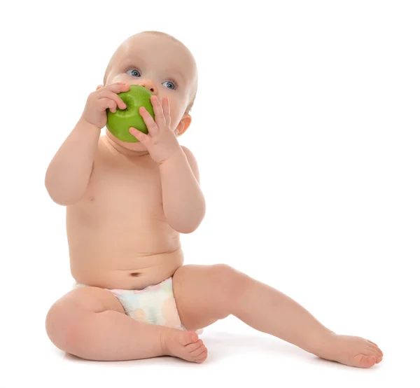 Happy child baby boy sitting in diaper and eating green apple — Stock Photo, Image