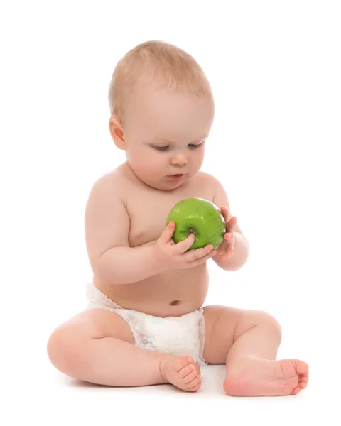 Szczęśliwe dziecko chłopca siedzi w pieluchy z zielonym jabłkiem — Zdjęcie stockowe