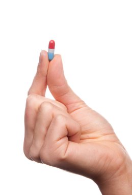 Hand hold medical painkiller pill capsule medicine in red and bl clipart