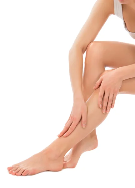 Woman touching hands and legs with french manicured nails — Stock Photo, Image