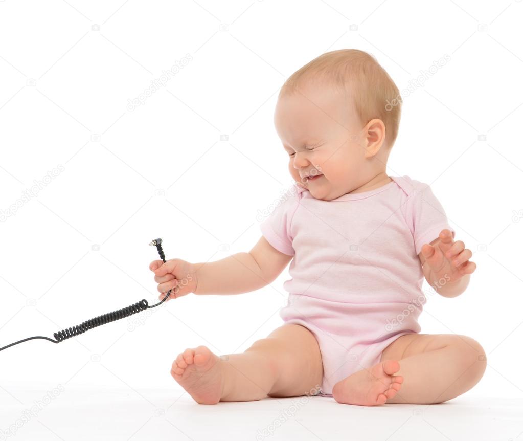 Child baby girl toddler sitting with wire cable expression of el