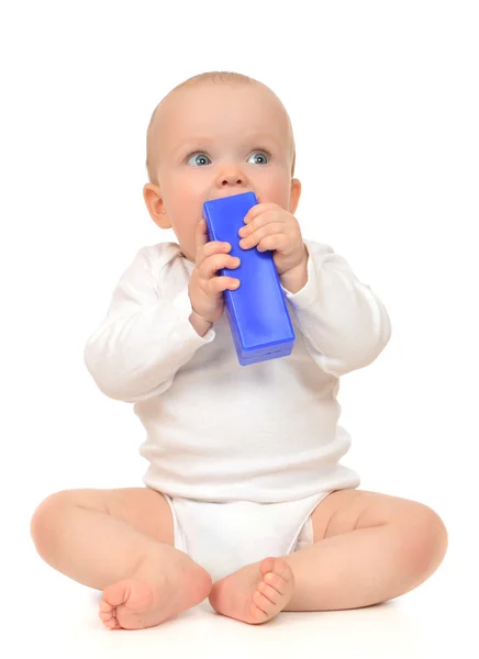 Bonito criança bebê menina criança sentado e comendo tijolo de brinquedo azul — Fotografia de Stock