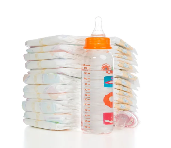 Child stack of diapers, nipple soother, baby feeding milk bottle — Stock Photo, Image