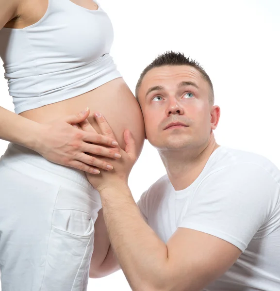 Man listenning infant baby in belly of his pregnant woman — Stock Photo, Image