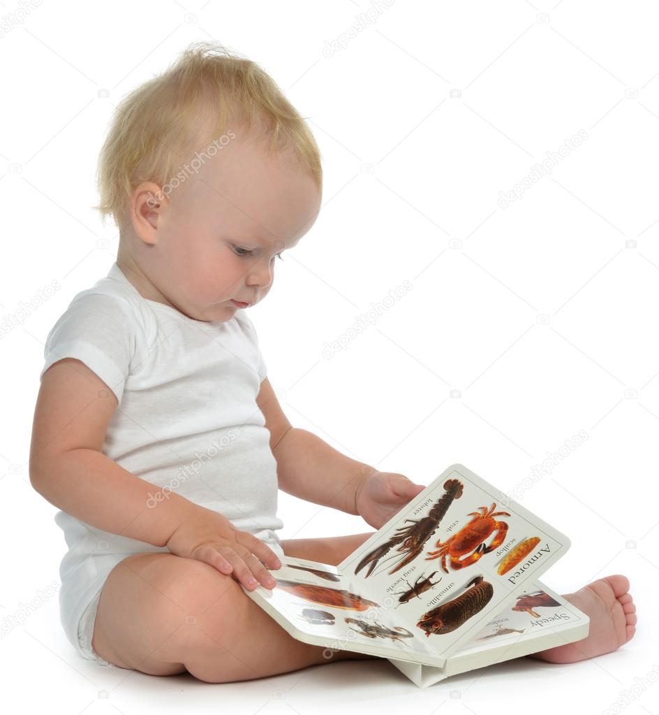 Infant child baby girl toddler sitting and reading book 