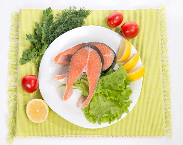 Raw salmon steak red fish on a plate decorated with vegetables — Stock Photo, Image