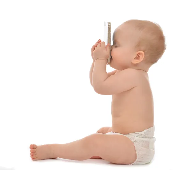 Glückliches Kind Baby Kleinkind sitzt lächelnd küsst Handy — Stockfoto