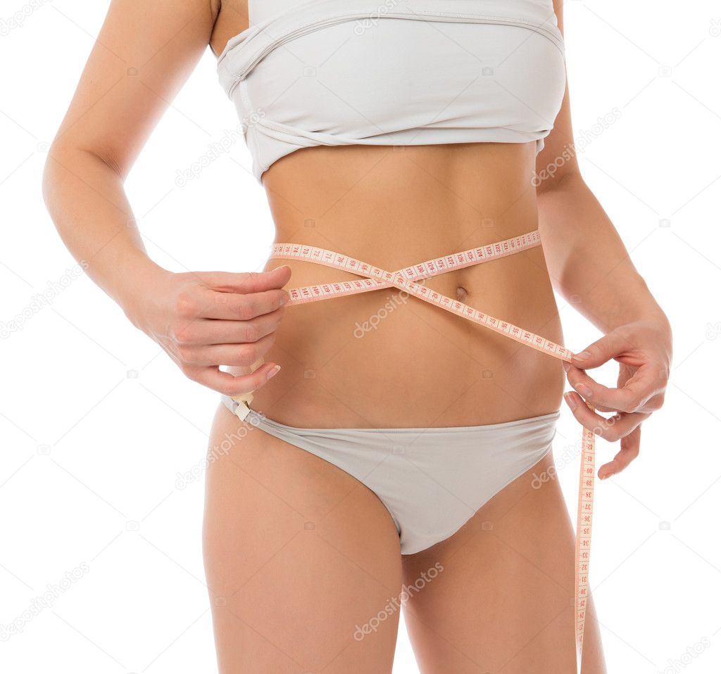Slim woman measuring waist with tape measure 