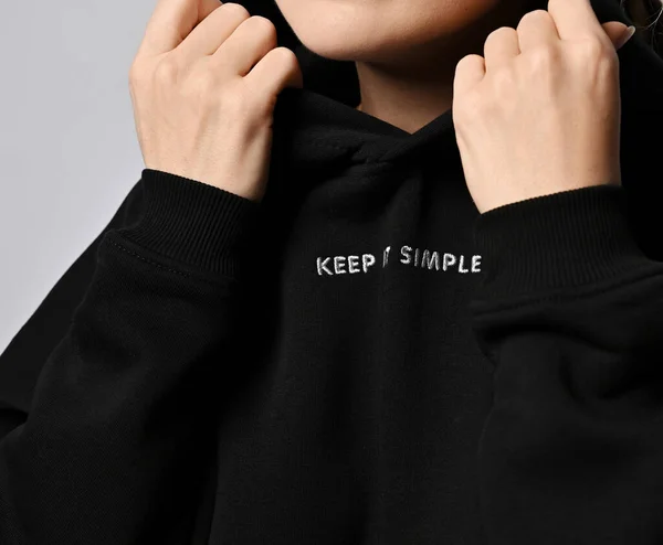 Szoros mellkas és nyak női divatos fekete kapucnis felső felirattal Tartsa egyszerű, tartja a csuklya kezével — Stock Fotó