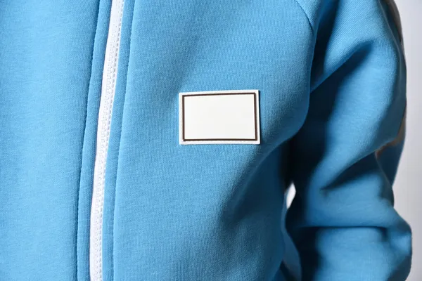 Closeup de criança em casaco azul com zíper e patch retangular em branco. Peito, manga — Fotografia de Stock