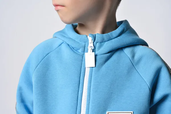 Nahaufnahme eines Jungen in blauem Overall oder Kapuzenpullover mit Reißverschluss, der mit gedrehtem Kopf zur Seite schaut — Stockfoto