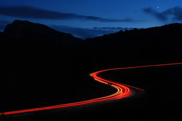 Night roads in the mountains with a stream of cars
