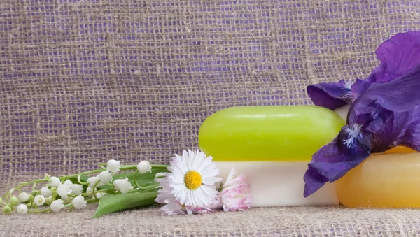 Pieces of soap with flowers on sacking cloth — Stock Photo, Image