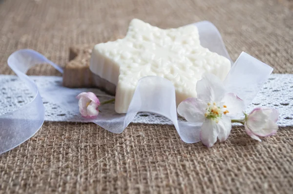 Sapone artigianale con nastri e fiori di mela su panno Foto Stock