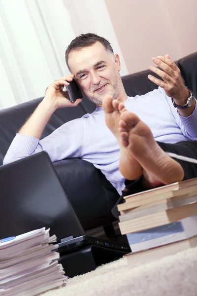 He works in the living room. — Stock Photo, Image