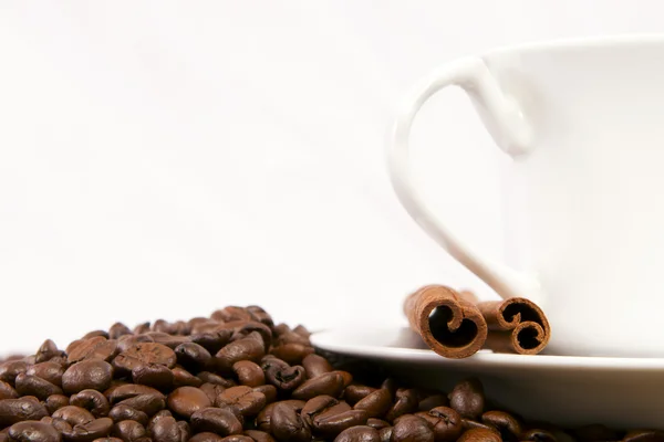 Uma xícara de café, e canela, grãos de café em torno dele . — Fotografia de Stock