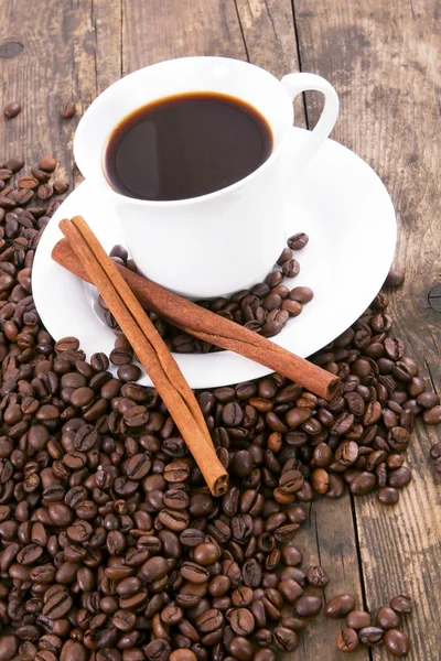 Bir fincan kahve ve tarçın, kahve çekirdeği etrafındaki. — Stok fotoğraf