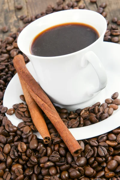 Koffiekopje met koffiebonen en kaneel. — Stockfoto