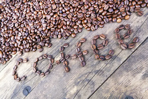 A palavra grãos de café colocou a mesa de madeira . — Fotografia de Stock