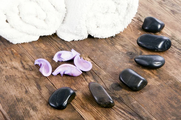 Toalhas e pedras no chão de madeira . — Fotografia de Stock