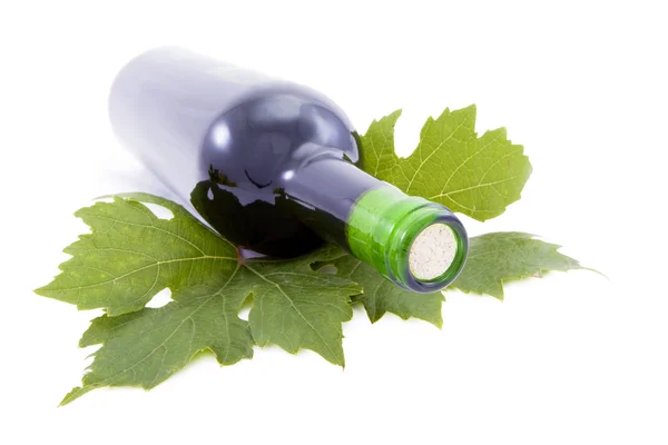 Fles wijn en druivenbladeren. — Stockfoto