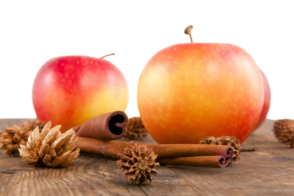 Яблоки и корица на деревянной доске . — стоковое фото