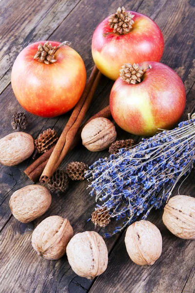 Mele, noci e cannella su tavola di legno . — Foto Stock