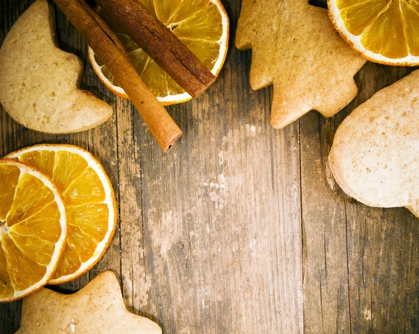 Pasteles y naranja dispuestos con buen gusto en la mesa de madera . — Foto de Stock