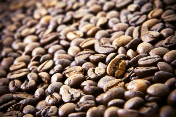 Med rostade kaffebönor hälla varandra. — Stockfoto