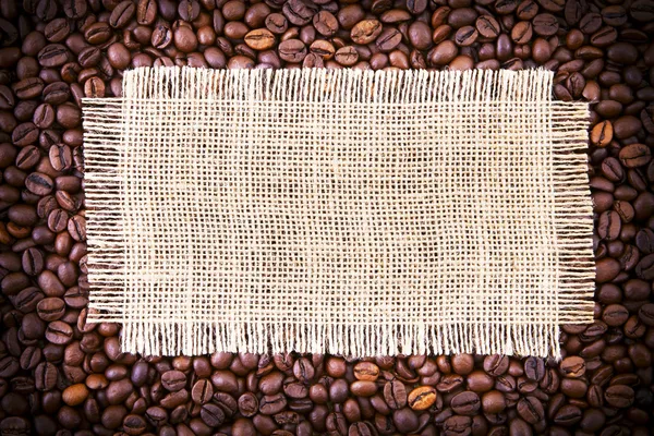 Grãos de café em rústico dispersando o tecido . — Fotografia de Stock