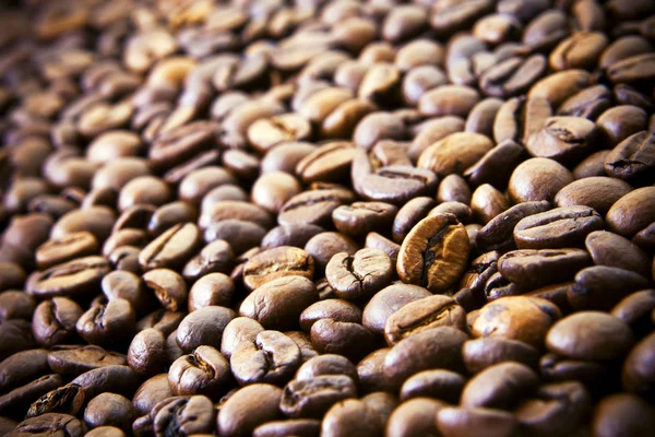 Com grãos de café torrados derramando uns aos outros . — Fotografia de Stock