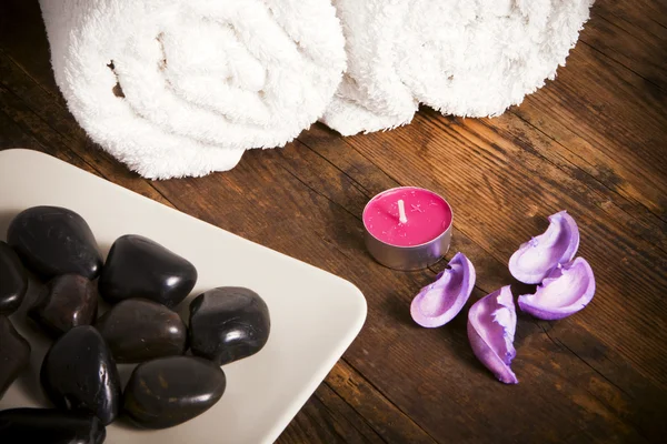 Handdoek naast kaarsen en kiezelstenen. — Stockfoto