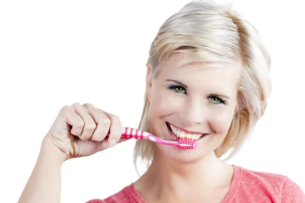 Vacker flicka med borstar sina tänder. Stockbild