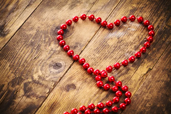 Collana di perle a forma di cuore, uno sfondo in legno . — Foto Stock