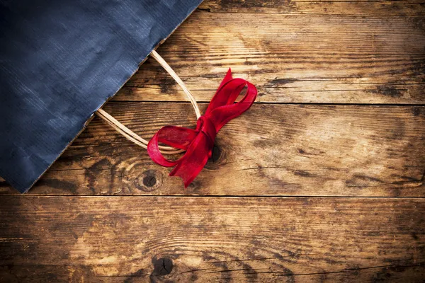 Geschenktasche mit Schleife auf dem hölzernen Hintergrund. — Stockfoto