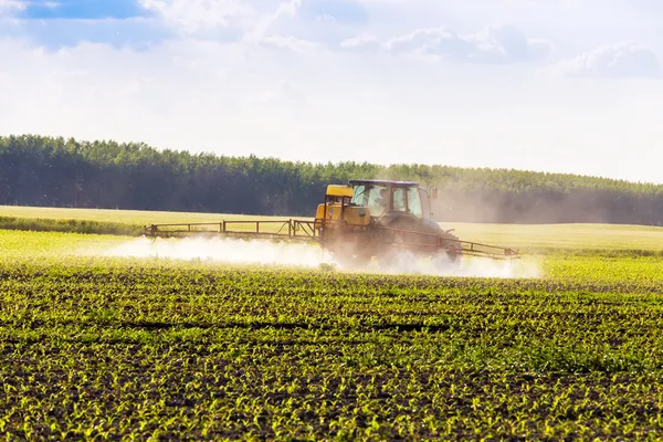 Boerderij trekker spuiten van een veld. Rechtenvrije Stockafbeeldingen