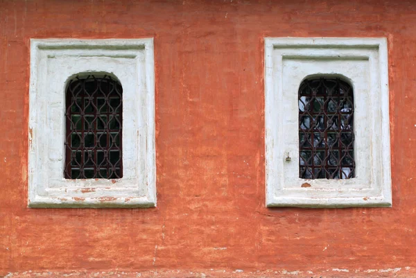 Dos ventanas con barras en la pared roja —  Fotos de Stock
