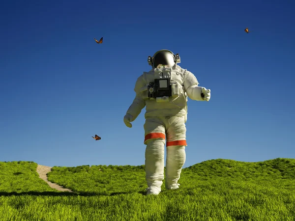 Astronauta caminhando na grama verde — Fotografia de Stock