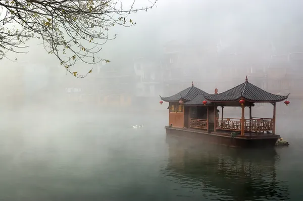 Китайский ландшафт лодки на туманной реке — стоковое фото