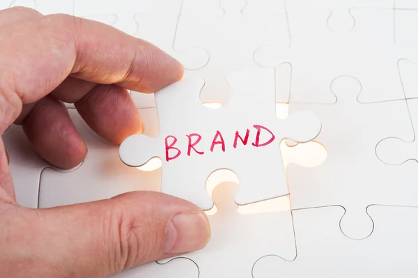 Puzzle which written brand — Stock Photo, Image