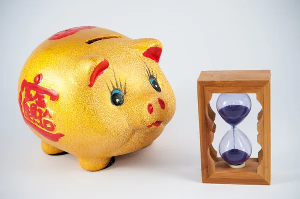 Piggy bank and hourglass — Stock Photo, Image