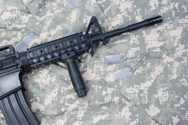 M4 carbine with blank dog tags on camouflage uniform — Stock Photo, Image